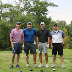 A golf team of four members at GOTR's golf tournament pose