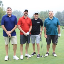 A golf team of four members at GOTR's golf tournament pose
